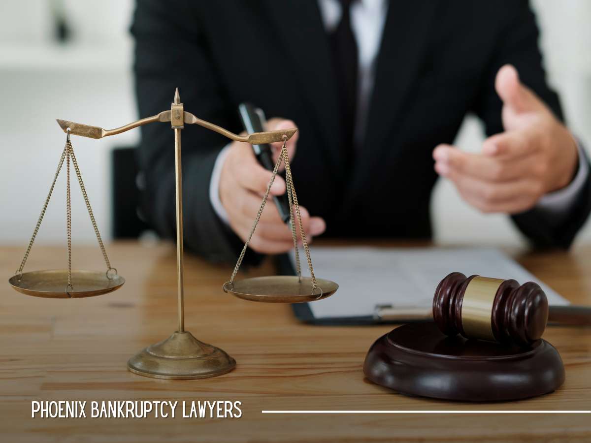 Lawyer in Phoenix, AZ gesturing during a consultation with scales of justice and a gavel on the desk, symbolizing Chapter 7 bankruptcy legal services.