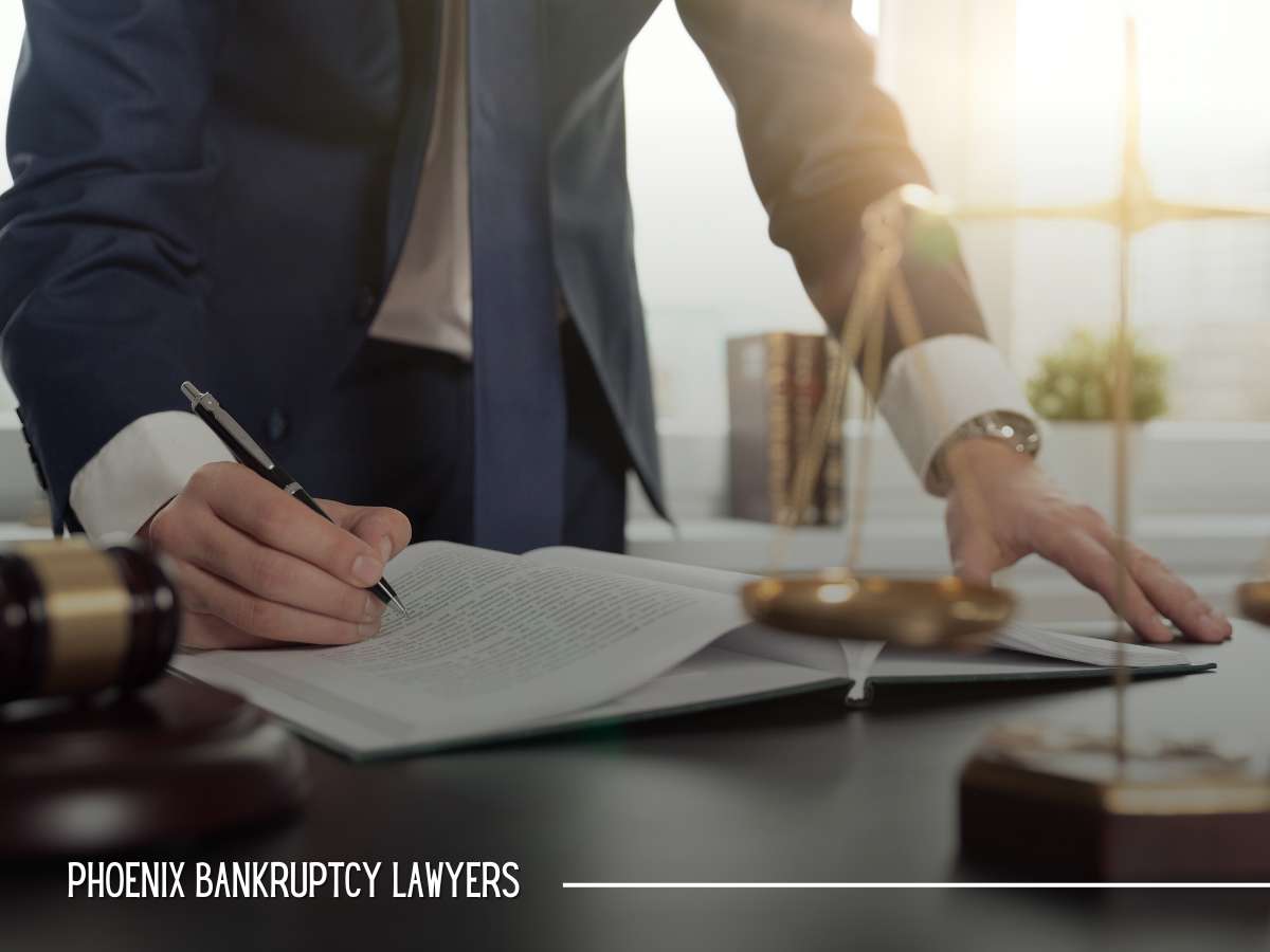 Phoenix Bankruptcy Lawyers discussing documents with scales of justice in the background, focusing on Bankruptcy services